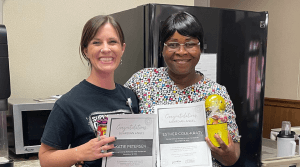 Two women smiling with their awards.