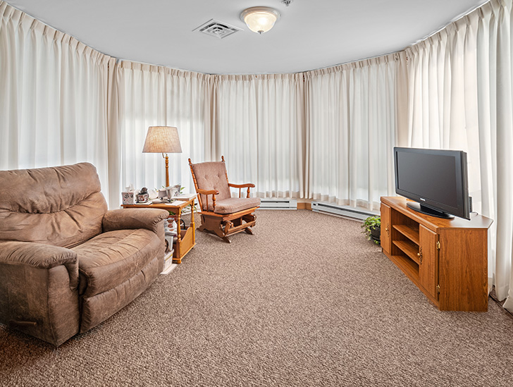 Spacious and naturally lit assisted living apartment living room at Good Samaritan Society - Prairie View Gardens in Kearney, Nebraska.