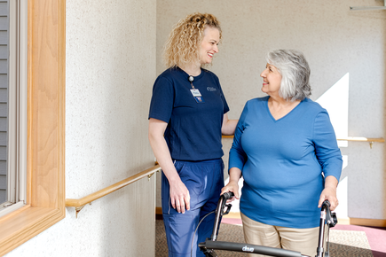 Nurse helping a woman holding a walker