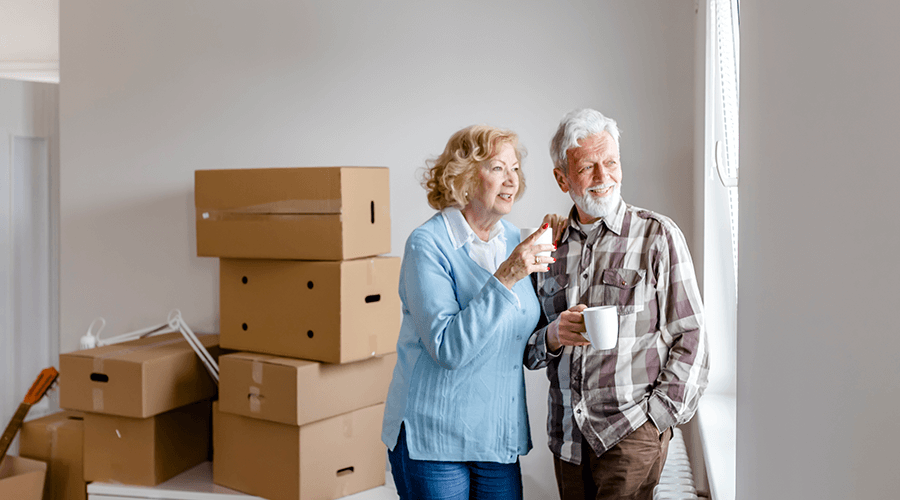 Senior couple looking outside their window as they downsize and get ready to move.