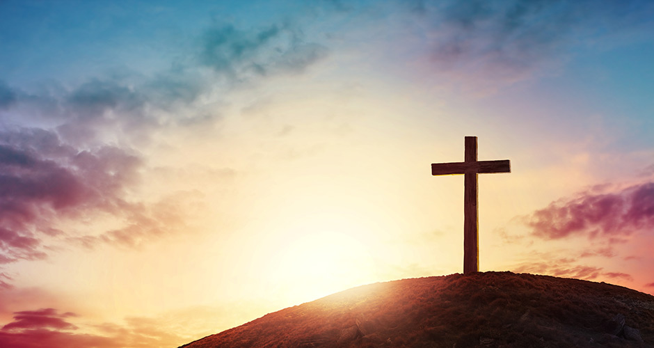 A cross on a hill at sunset representing the hope hospice brings