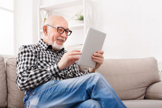 Our commitment to seniors Man scrolling on a tablet.