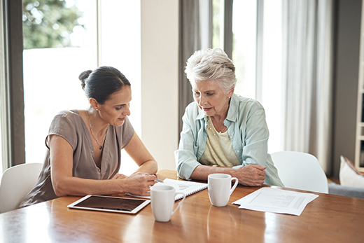 Senior and employee discussing types of care at a table.