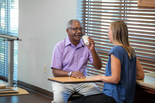 Older African American male working with a speech pathologist during speech therapy session at Good Samaritan Society.