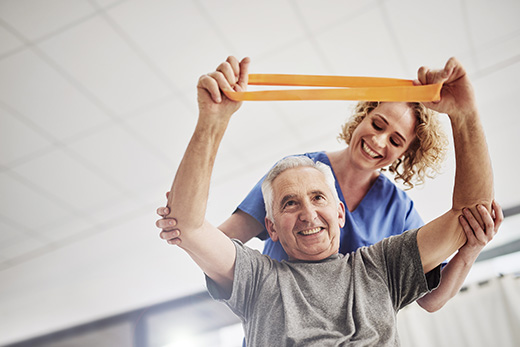 Older gentlemen working with physical therapist on arm strength at Good Samaritan Society.