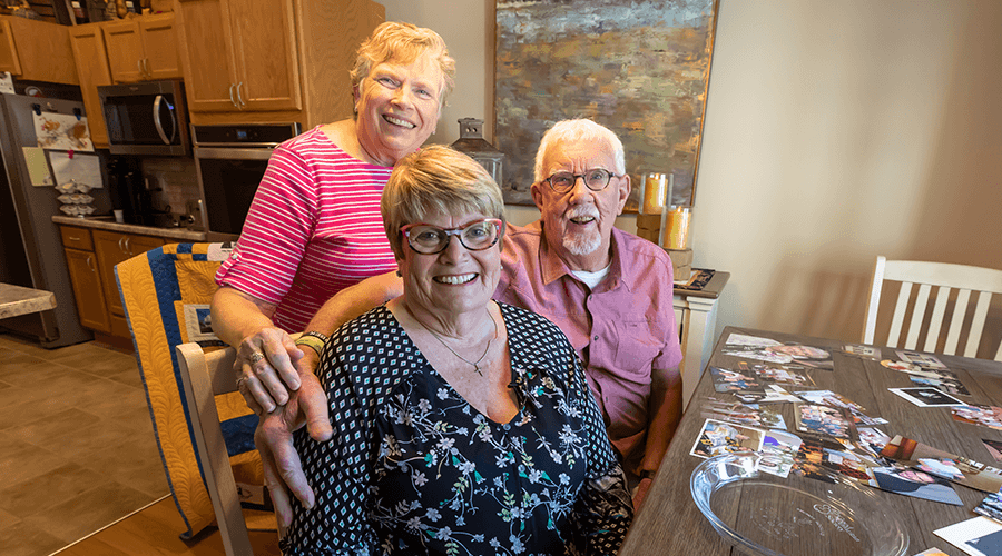 Former nursing home administrator, Cindy Moegenburg, sitting with family members around kitchen table reflecting on memories at Good Samaritan Society