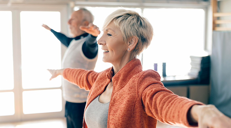 Two people with arms upraised for a balance class