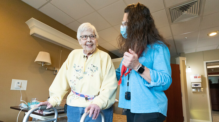 Susan Packer using a walker next to her therapist