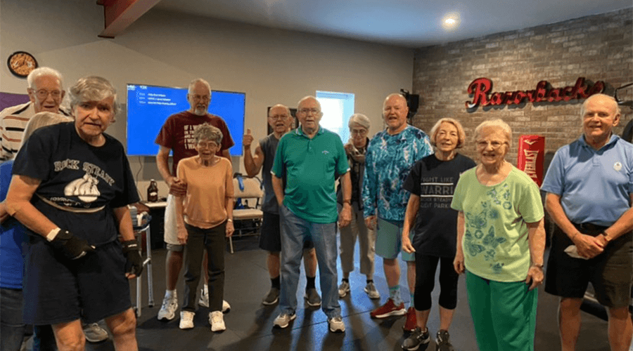Twelve people standing in the Rock Steady gym