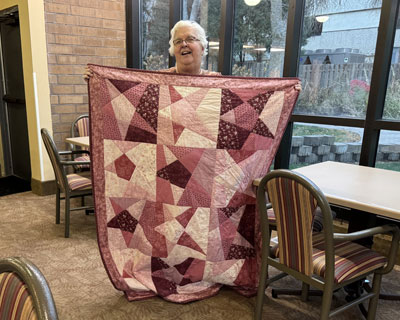 Gerry Poppler holding her quilt.