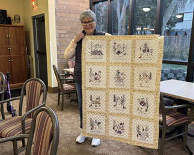 Myrene Whittaker holding her quilt.