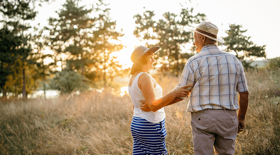 Stock photo of a senior couple walking at sunset